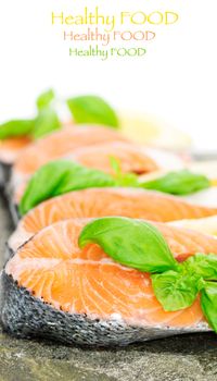 Salmon cuts on stone with basil and lemon isolated on white, copy space