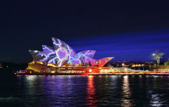 SYDNEY, AUSTRALIA - JUNE 2, 2015;   Light beams stream onto the iconic landmark, the Sydney Opera House casting various moving patterns during Vivid Sydney annual festival event.