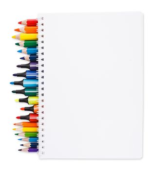 notebook with colored pencils and markers on white background with space for text, clipping path