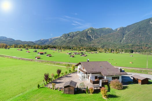 Alpine mountains summer lanscape with green meadow and pasture in valley and blue sky