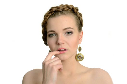 Female model with earrings. Young girl with blond hairs, holding finger near her lips.