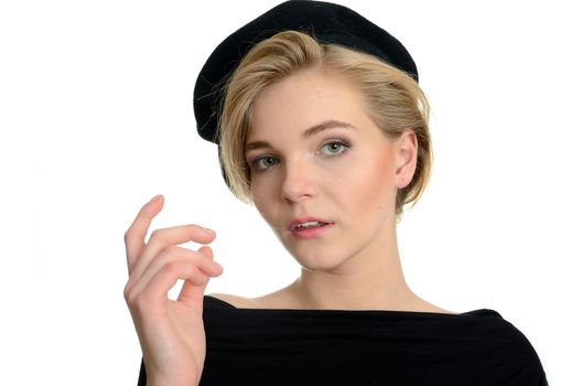 Elegant female model with kind face expression. Young girl with blond hairs, black top and black beret.