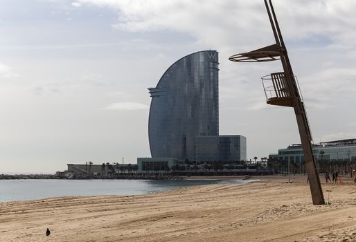 A sandy beach in Barcelona, Spain with buildings in the background