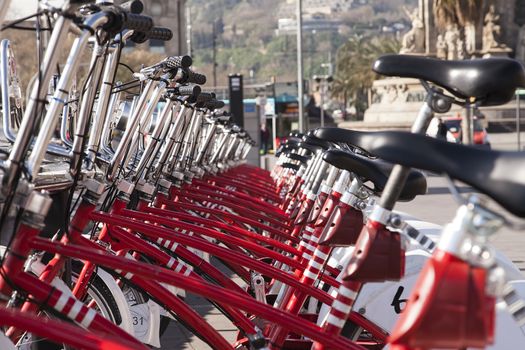 A set of red bikes and a city in the background