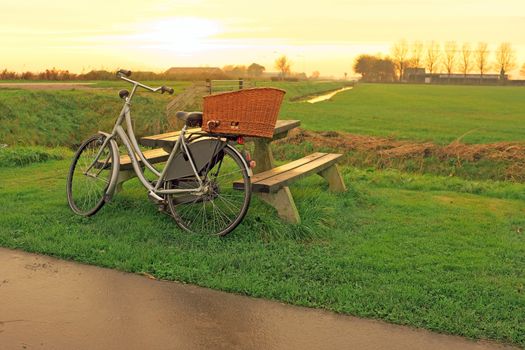 Bike against a picnic bench in the countryside from the Netherlands at twilight