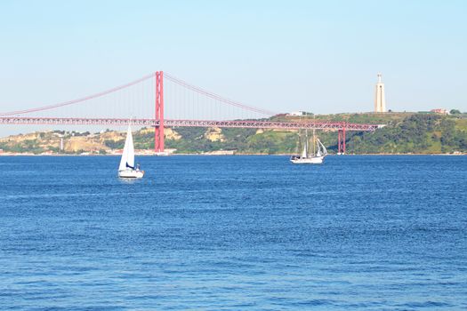 Sailing on the river Tejo with the 25 Abril bridge and the Christo Rei in Lisbon Portugal