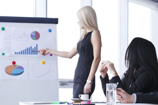 Workers at business meeting looking at presentation of financial reports in modern office