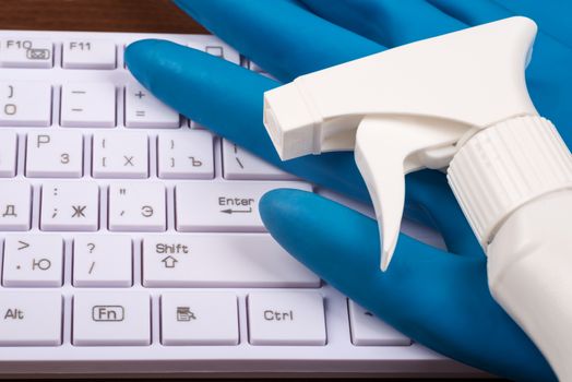 Airbrush with rubber gloves and keyboard on brown wooden table