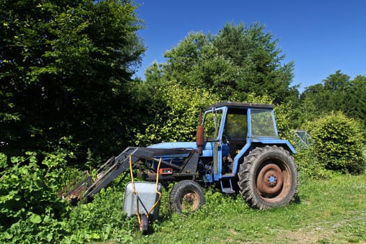 Old blue tractor abandonned in the nature