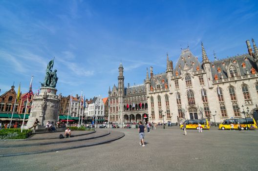Bruges, Belgium - May 11, 2015: Tourist on Grote Markt square in Bruges, Belgium on May 11, 2015. The historic city centre is a prominent World Heritage Site of UNESCO.