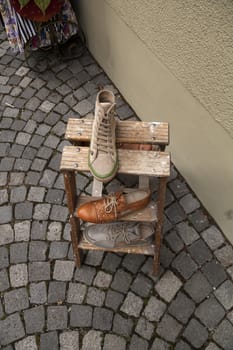 Shoes on a stool from above on a cobblestone street