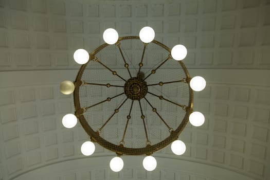 A circular lamp in a waiting hall with one broken