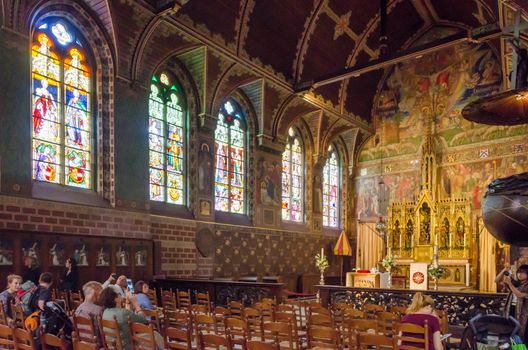 Bruges, Belgium - May 11, 2015: Tourist visit Interior of Basilica of the Holy Blood in Bruges, Belgium on May 11, 2015. Basilica is located in the Burg square and consists of a lower and upper chapel. 