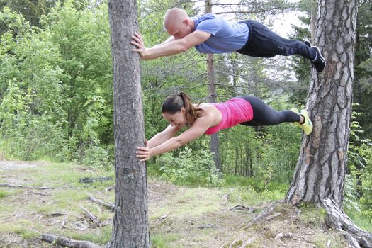 Lasse Tufte og bloggeren Maren Erdvik bak Fitliving viser treningsøvelser i skogen.