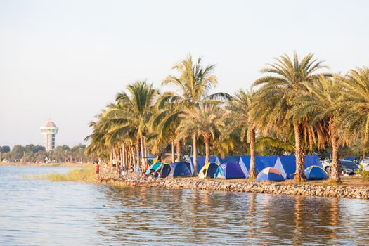 Tent are located along lake. Tourist attractions during the holidays.