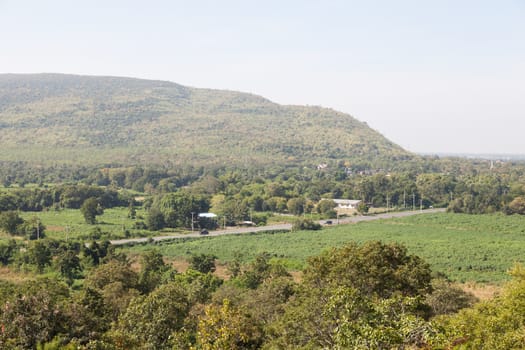 road through the agricultural area. Close to the mountains and trees.