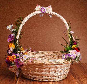 basket decorated with flowers on wooden table