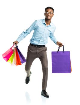 Happy african american man holding shopping bags on white background. Holidays concept