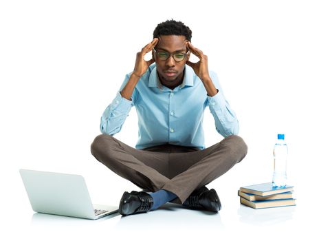 Happy african american college student with laptop, books and bottle of water sitting on white background