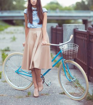 Young beautiful, elegantly dressed woman with bicycle. Beauty, fashion and lifestyle