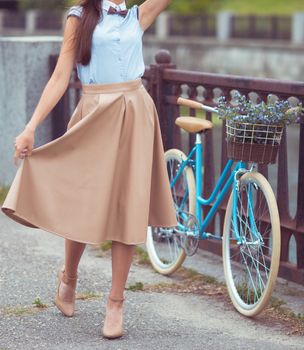 Young beautiful, elegantly dressed woman with bicycle. Beauty, fashion and lifestyle