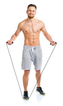 Athletic attractive man jumping on a rope on the white background