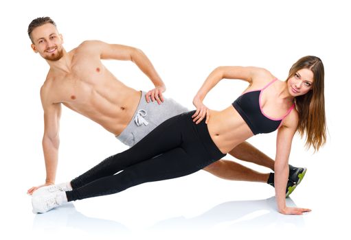 Attractive sport couple - man and woman doing fitness exercises on the white background