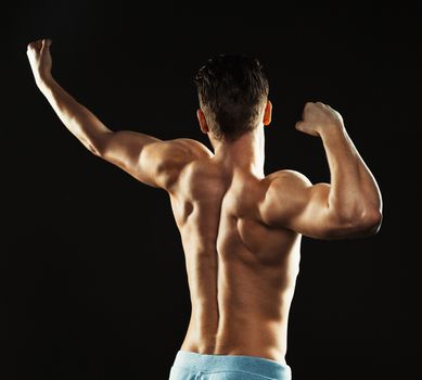 Athletic attractive man on the black background