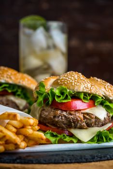 Closeup of Homemade Hamburger with Fresh Vegetables and Drink with Ice in Background