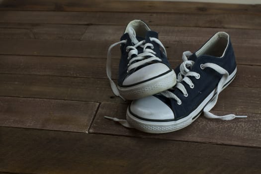 Old worn shoes left on a wooden floor