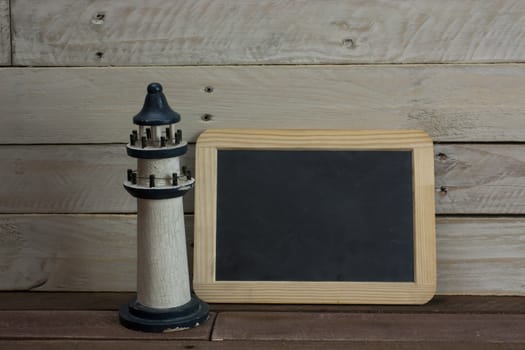 Lighthouse and blackboard set against a worn wooden background