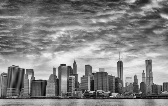 Black and white view of Lower Manhattan with dramatic sky.