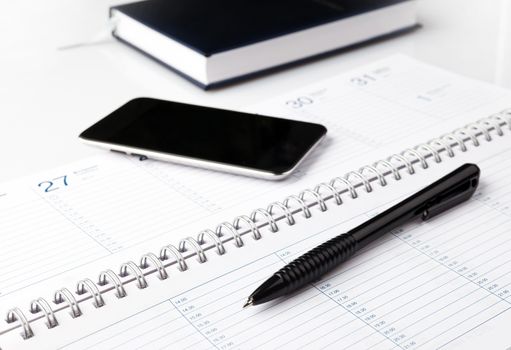 notepad with pen and electronic notebook on a white background