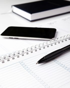 notepad with pen and electronic notebook on a white background