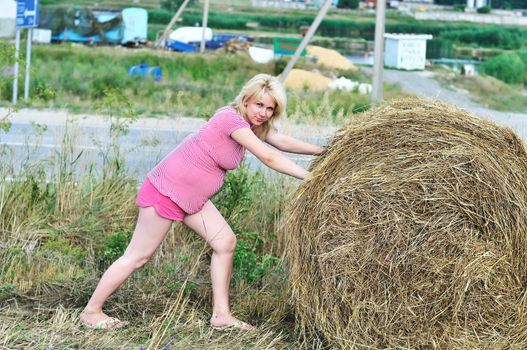 humorous photo of working pregnant woman in field