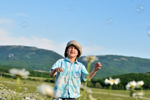 little boy wants to catch soap bubbles 