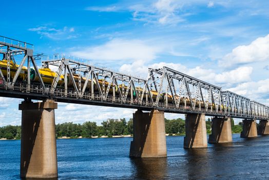 Petrivskiy railroad bridge in Kyiv across the Dnieper with freight train on it.