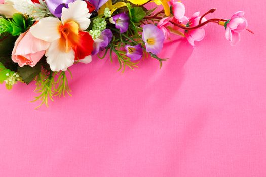artificial flowers  on pink background with place for label advertisement