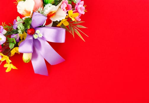 artificial flower arrangement on a red background with space for greetings