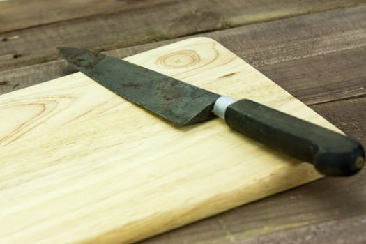 Wooden chopping board with an old knife