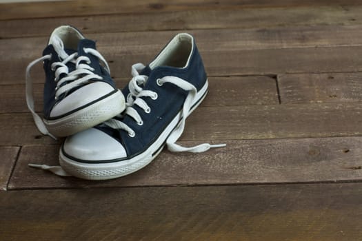 Old worn shoes left on a wooden floor