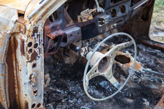 Burnt car interior with steering wheel after the accident