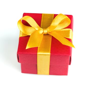 red gift box with golden ribbon and bow isolated on white top view
