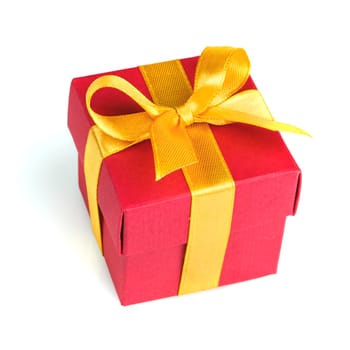 red gift box with golden ribbon and bow isolated on white top view