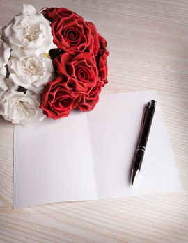 blank card with a pen, white and red roses