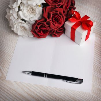 blank card with a pen,gift box white and red roses 
