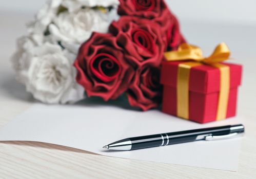 Greeting blank card with pen, rose and red box with yellow ribbon