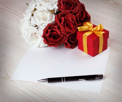 Greeting blank card with pen, rose and red box with yellow ribbon