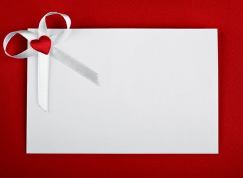 greeting card with heart and bow on red background