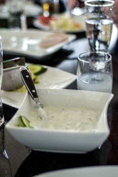 Pixture of a Tzatziki on a restaruant dinner  table 